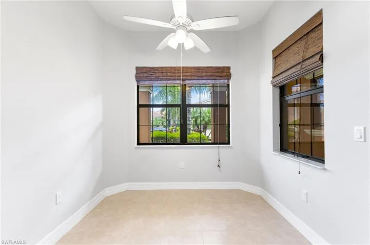 Tiled spare room featuring ceiling fan