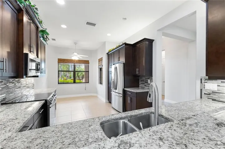 Kitchen featuring decorative backsplash, appliances with stainless steel finishes, and sink
