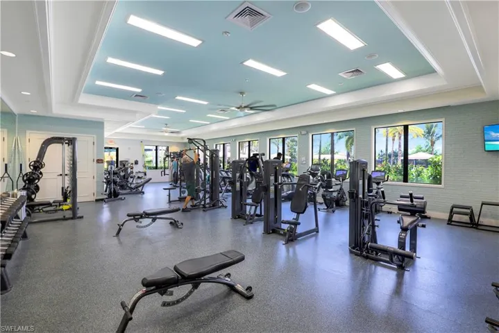 Exercise room featuring a tray ceiling and ceiling fan