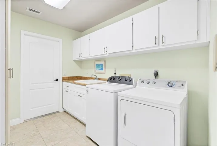 Laundry room, Tub sink, washing machine and clothes dryer, and cabinets