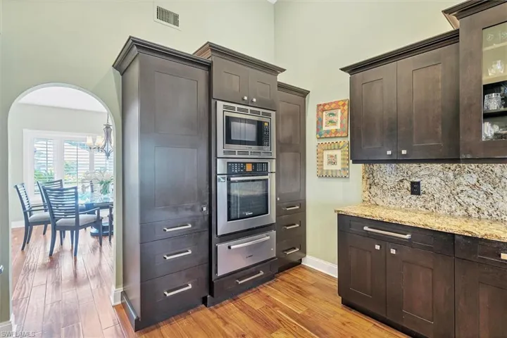 Kitchen featuring dark brown cabinetry, stainless steel appliances, and light wood-type flooring