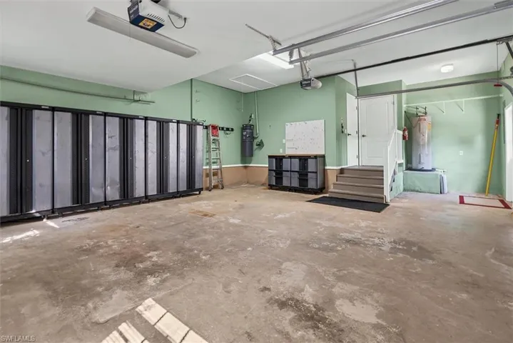 Garage featuring cabinets, water heater and access to Laundry room
