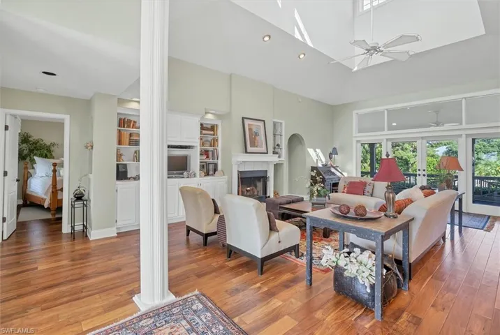 Living room with high vaulted ceiling, decorative columns,