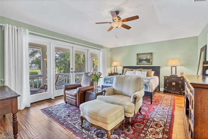 Bedroom featuring access to exterior, wood-type flooring, lofted ceiling, ceiling fan, and french doors