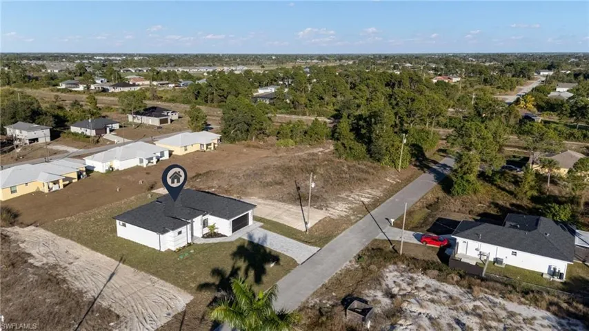 Aerial view of property and surrounding area featuring nearby suburban area