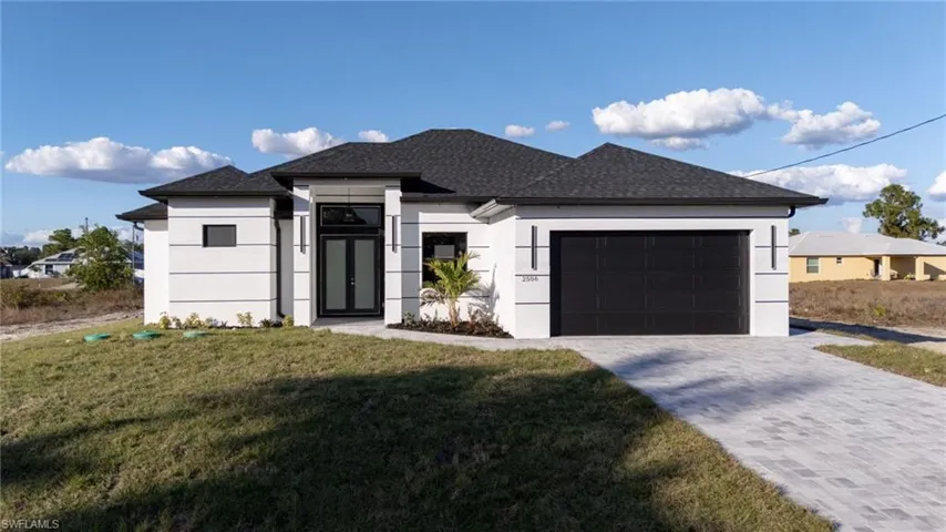 View of front of property featuring roof with shingles, a front lawn, stucco siding, decorative driveway, and an attached garage