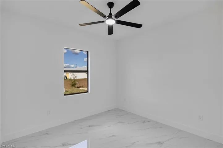 Unfurnished room with light marble finish floors and ceiling fan
