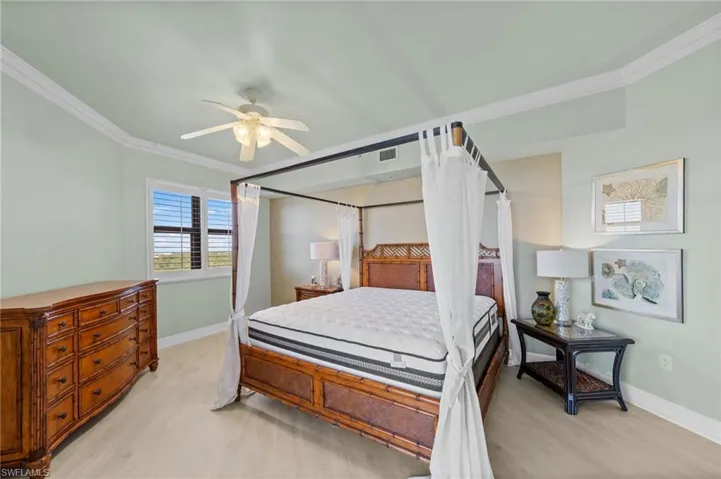 Bedroom featuring light-colored flooring, a window with horizontal blinds, and a ceiling fan