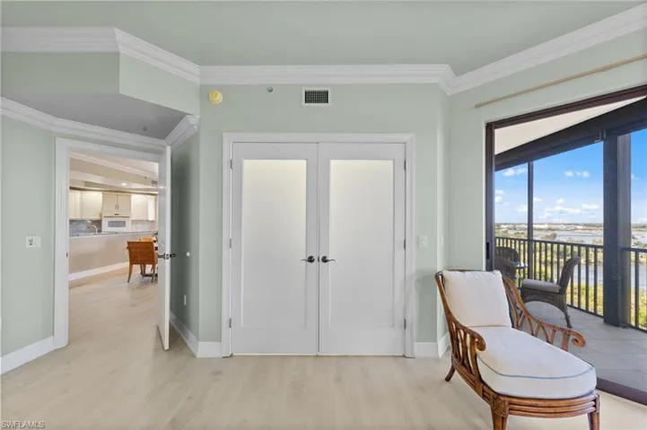 The property features light wood flooring, light green walls, white crown molding, and white baseboards