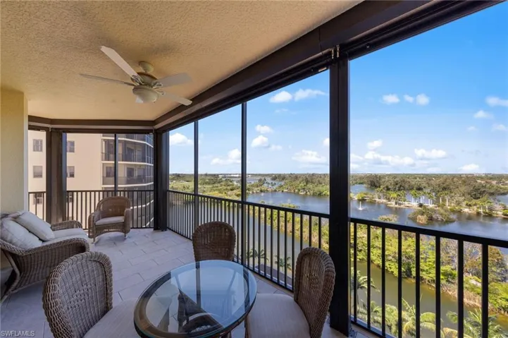 Spacious balcony featuring tile flooring and a ceiling fan, offering expansive views of the lake and surrounding greenery