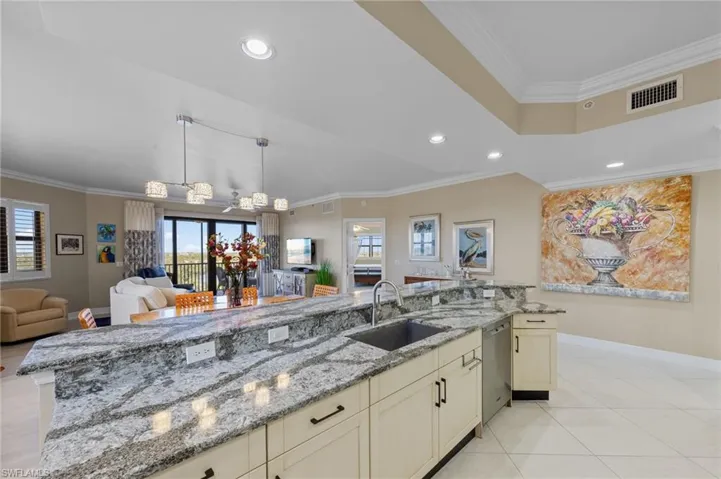 The kitchen features an expansive granite countertop with an integrated sink and light-colored cabinetry