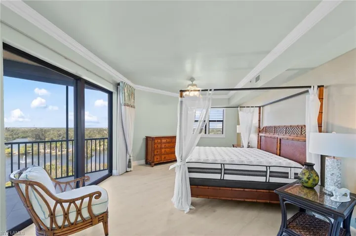 The bedroom features light-colored flooring, a glass sliding door providing access to a balcony, and a window with horizontal blinds
