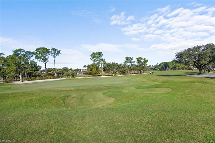 Surrounding community with golf course view and a lawn