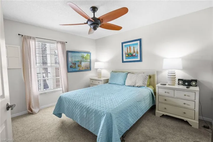 Carpeted bedroom featuring ceiling fan and a textured ceiling