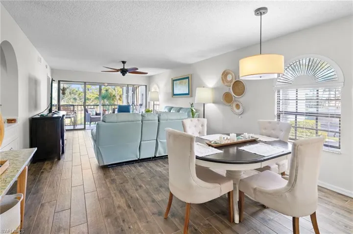 Dining room featuring a textured ceiling, wood finished floors, and a ceiling fan