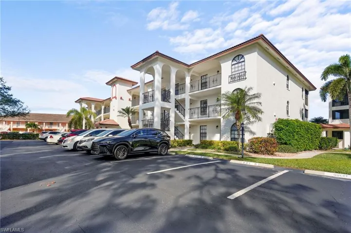 View of apartmenbuilding / complex featuring uncovered parking