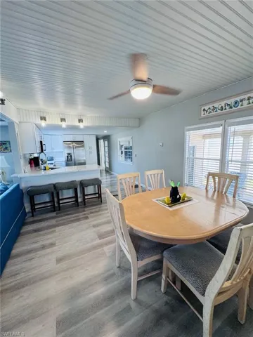 Wood-finish flooring throughout, beadboard ceiling, recessed ceiling lighting, kitchen island with built-in cabinetry, and stainless steel appliances