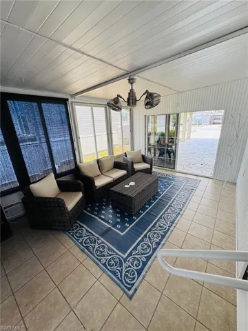 Screened-in porch featuring tiled flooring, a slatted ceiling, and multiple window panels