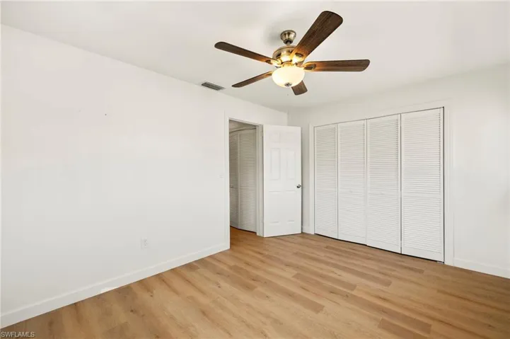 Unfurnished bedroom with light wood-style floors, ceiling fan, and a closet