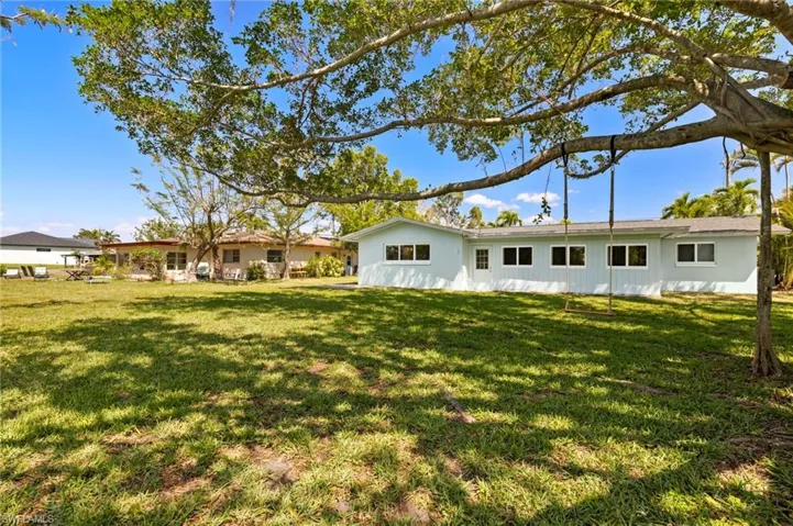 Rear view of property with a lawn