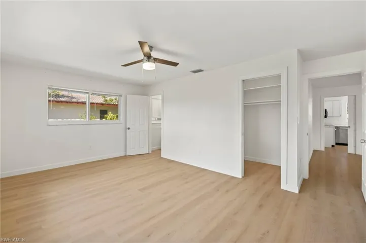 Unfurnished bedroom featuring light wood finished floors, a walk in closet, and ceiling fan