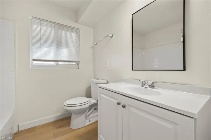 Full bathroom with vanity and light wood-style floors