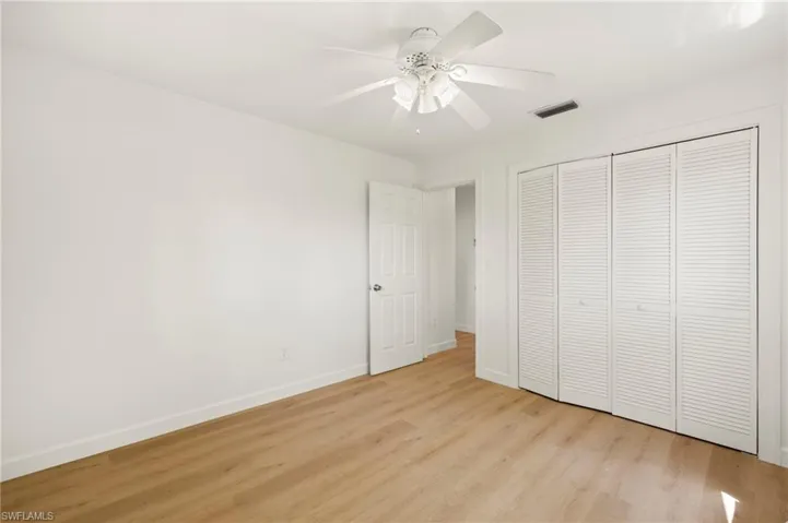 Unfurnished bedroom with light wood finished floors, a ceiling fan, and a closet