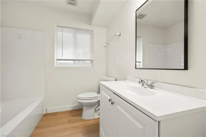 Bathroom featuring vanity, light wood-type flooring, and shower / tub combination