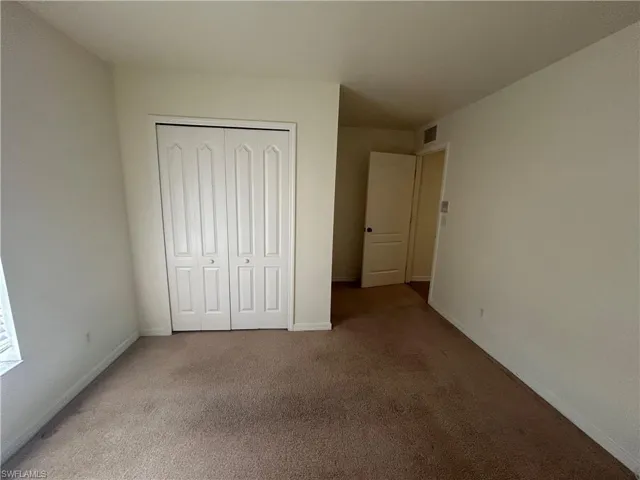 Unfurnished bedroom featuring carpet floors and a closet