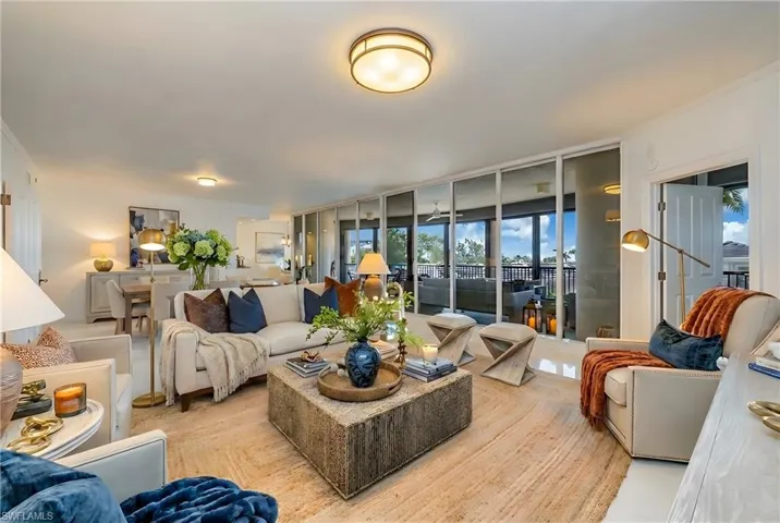 Living room featuring healthy amount of natural light, expansive windows, and ornamental molding