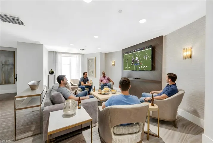 Living room featuring an accent wall, recessed lighting, and wood finished floors