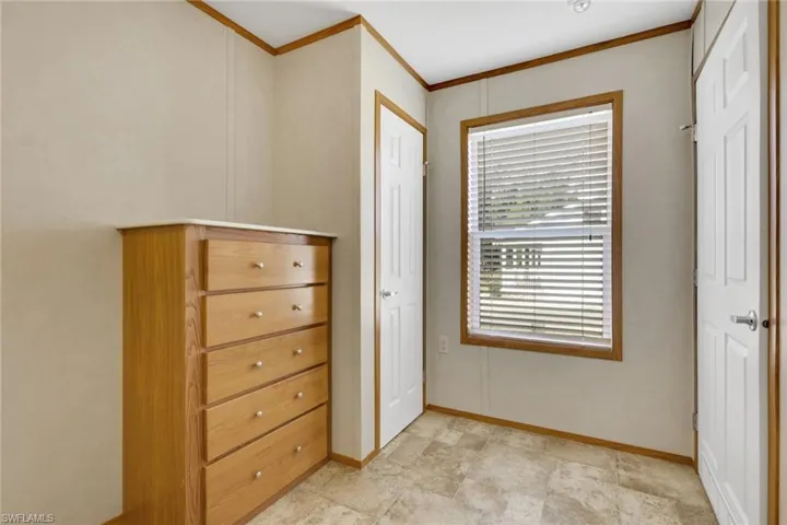 Bedroom featuring crown molding and baseboards