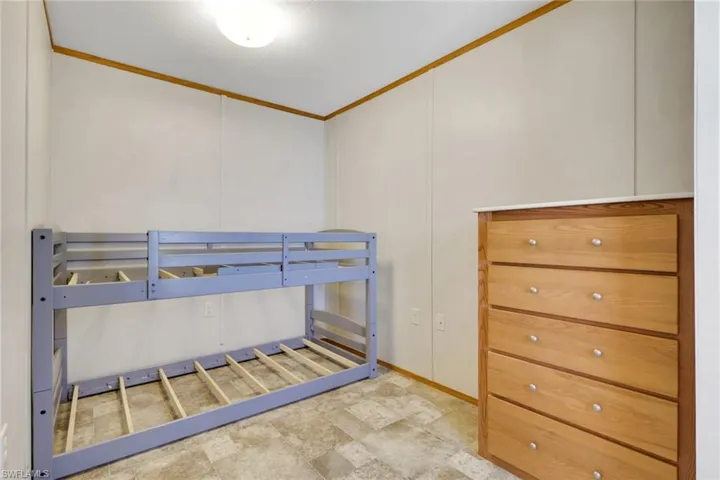Bedroom with ornamental molding and a decorative wall