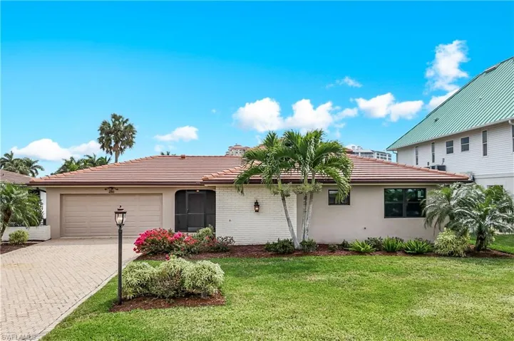 View of front facade with decorative driveway, a garage, a tiled roof, and stucco siding