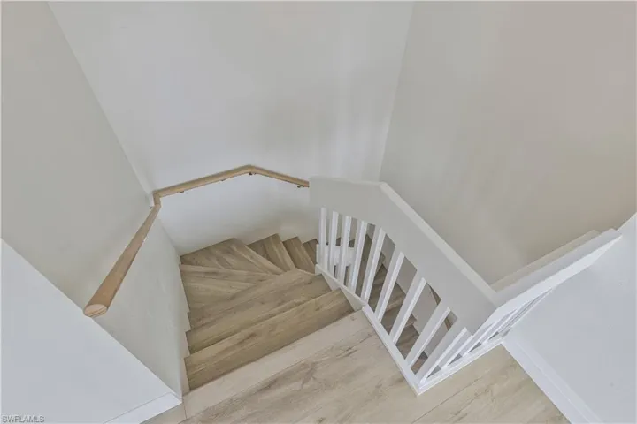 Stairway featuring wood finished floors