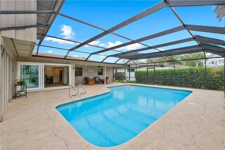 View of pool with a sunroom, a lanai, and patio surround