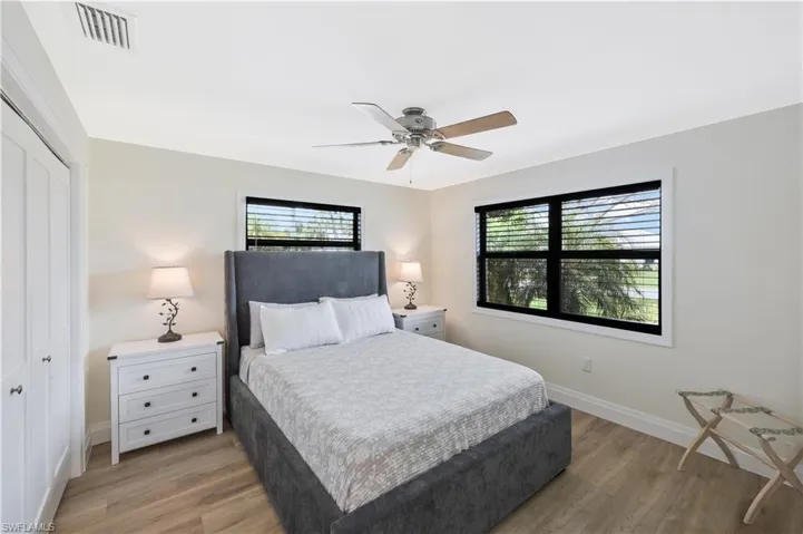 Bedroom with light wood-style floors, ceiling fan, and a closet