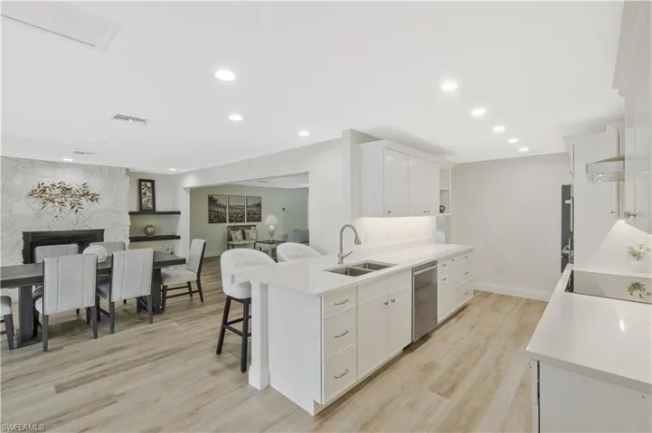 Kitchen with a peninsula, open floor plan, white cabinets, a kitchen breakfast bar, and open shelves