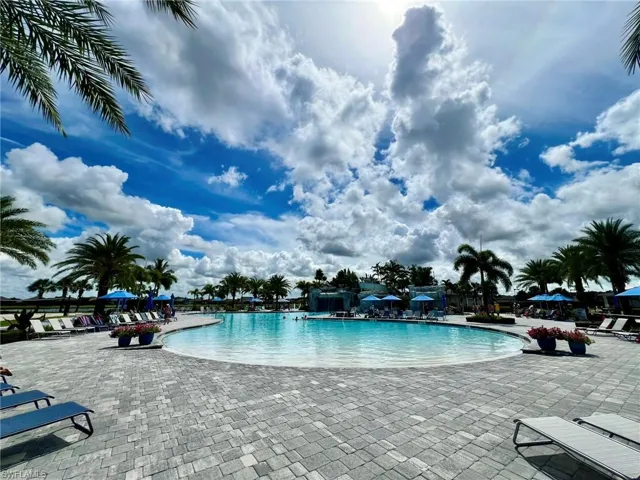 Large Resort Style beach entry swimming pool with waterfalls and slide.