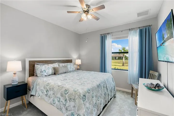 First floor bedroom with ceiling fan and light carpet.