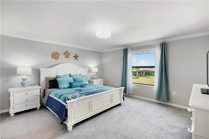 Carpeted bedroom featuring crown molding and walk in closet area.