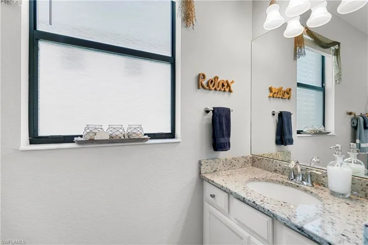 First floor bathroom featuring granite countertops and tub.