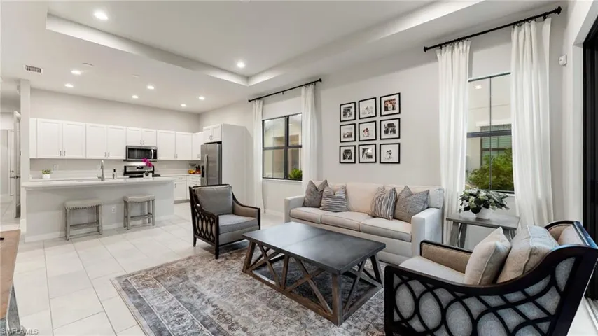 Large beautiful open space with tray ceiling, recessed lighting, and lovely natural light through windows.
