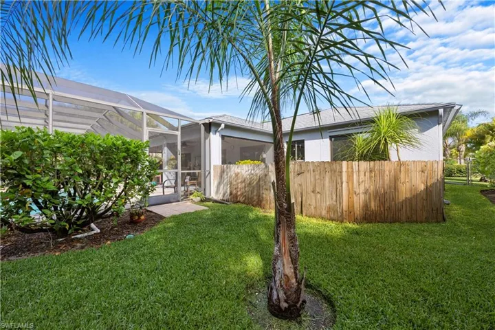 View of yard featuring glass enclosure and fence