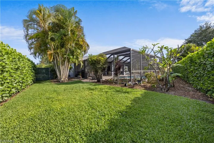 View of yard with fence, an outdoor pool, and glass enclosure