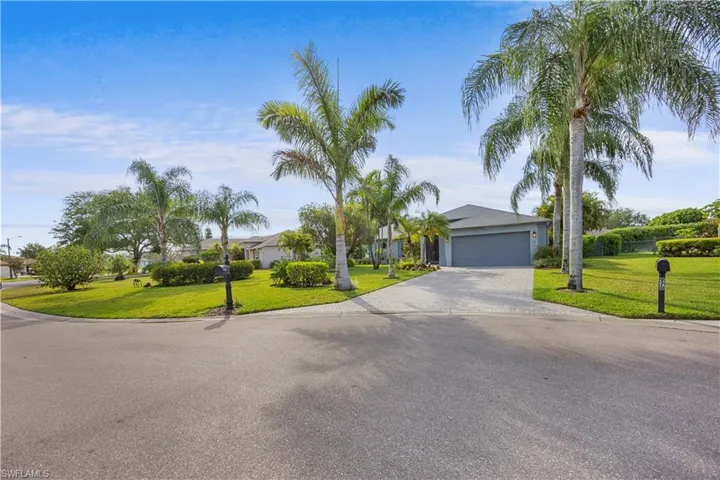 View of front of property with driveway, a front yard, and an attached garage