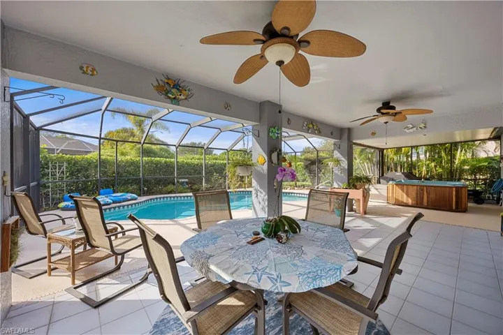 View of patio / terrace with ceiling fan, a hot tub, and an outdoor pool
