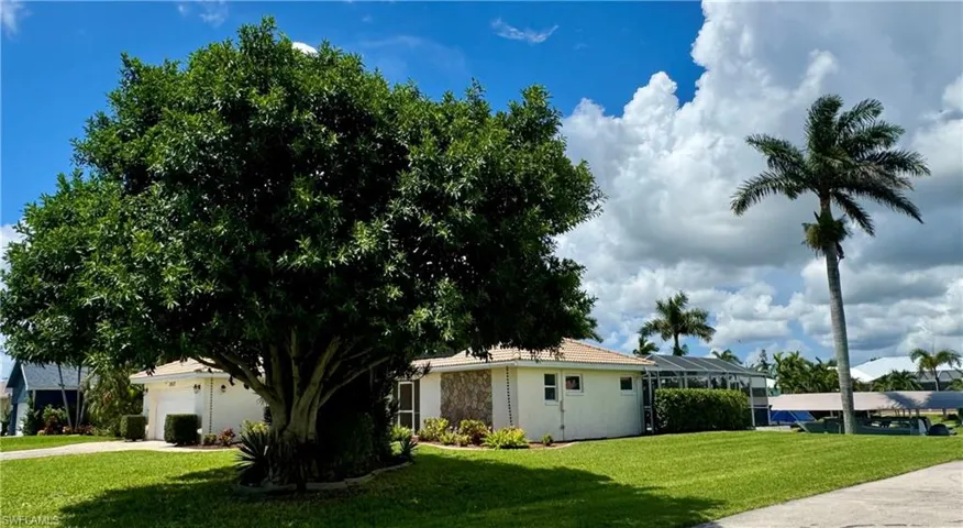 Single story home with a front lawn, a lanai, a garage, and driveway