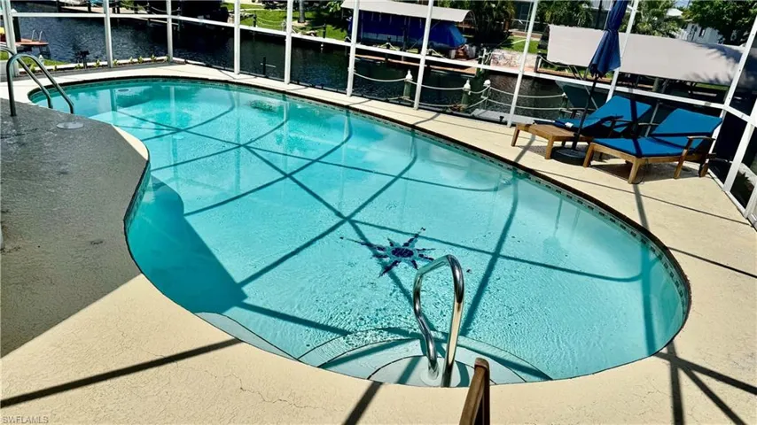 Swimming pool with a water view and a patio