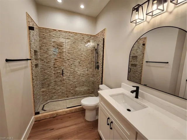 Bathroom with vanity, a stall shower, dark wood-style floors, and recessed lighting